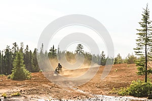 Man driving ATV quad in sandy terrain with high speed.