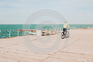 Man driving bicycle on the beach in sunny day.
