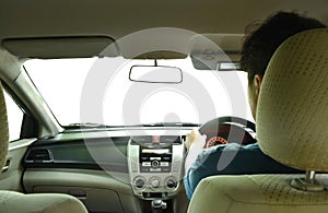Man driving in car cockpit with white windshield background