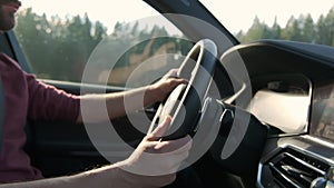 Man driving car. hand on the steering wheel against the background of the road