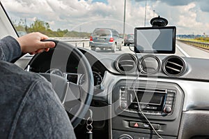 Man driving car with hands on the steering wheel and using the GPS navigation