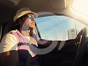 Man driving car with hat and sunglasses