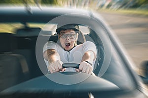 Man driving car in helmet with horror on her face