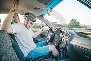 Man driving car in helmet with horror on her face