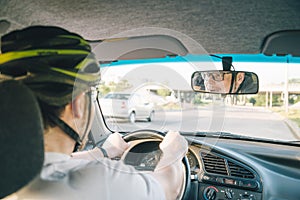 Man driving car in helmet with horror on her face