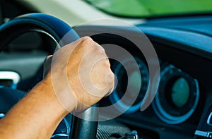 Man driving car with his hand on the steering wheel