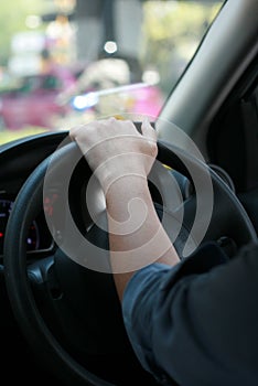 Man driving car with his hand on the steering wheel
