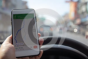 Man driving car and holding mobile phone with map gps navigation