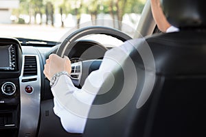 Man driving a car and looking at watch