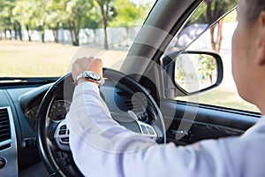 Man driving a car and looking at watch