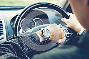 Man driving a car and looking at watch