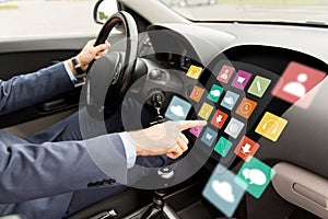 Man driving car with menu icons on board computer