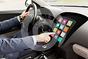 Man driving car with menu icons on board computer