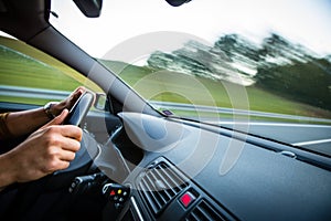 Man driving a car moving fast on a highway