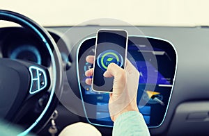 Man driving car and setting eco mode on smartphone