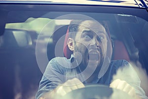 Man driving a car shocked about to have traffic accident, windshield view