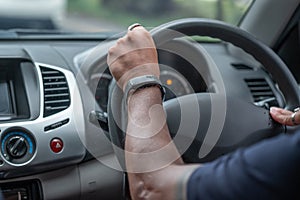 a man driving in a car and smart watch in his hand