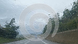 Man driving a car on stormy rain motorway traffic,climate changes,wheater conditions