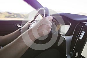 Man driving a car. Success in motion. Handsome young man driving a car. A man holds the steering wheel of a car