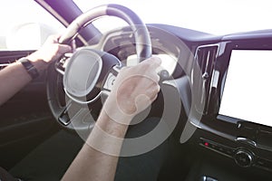 Man driving a car. Success in motion. Handsome young man driving a car. A man holds the steering wheel of a car