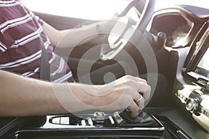 Man driving a car. Success in motion. Handsome young man driving a car. A man holds the steering wheel of a car