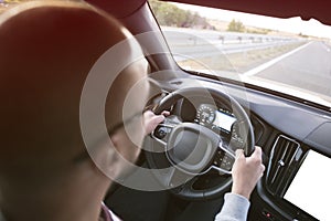 Man driving a car. Success in motion. Handsome young man driving a car. A man holds the steering wheel of a car