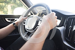 Man driving a car. Success in motion. Handsome young man driving a car. A man holds the steering wheel of a car