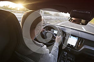 Man driving a car. Success in motion. Handsome young man driving a car. A man holds the steering wheel of a car