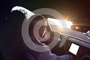 Man driving a car. Success in motion. Handsome young man driving a car. A man holds the steering wheel of a car