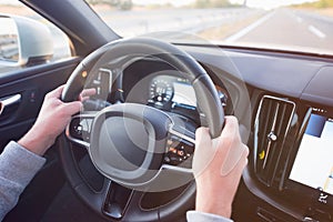 Man driving a car. Success in motion. Handsome young man driving a car. A man holds the steering wheel of a car