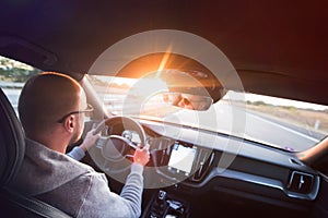 Man driving a car. Success in motion. Handsome young man driving a car. A man holds the steering wheel of a car