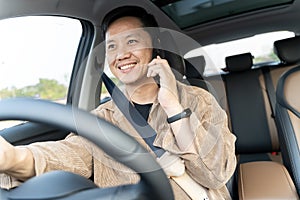 A man is driving a car and talking on his cell phone