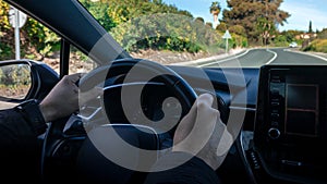 Man driving car. Unrecognizable driver holding hands on steering wheel