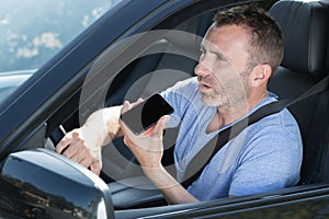 man driving car and using mobile phone