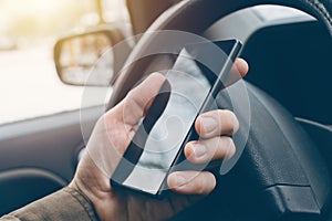 Man driving car and using mobile phone for texting