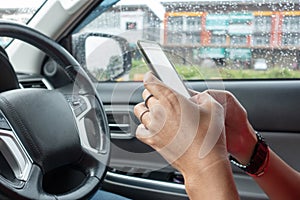 Man driving car using mobile phone texting message.