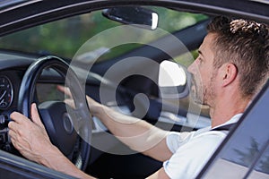 Man driving car using one hand