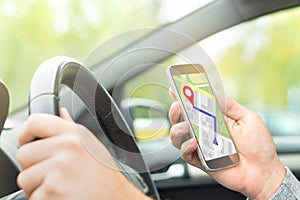 Man driving car and using online map and GPS application.