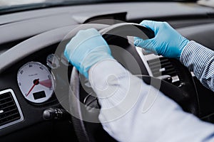 Man driving a car wearing protective mask and gloves during pandemic coronacirus covid-19