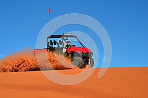 Man Driving a Four Wheeler on Sand with Blue Sky
