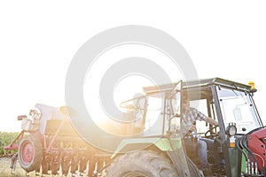 Man driving harvester against sky at farm