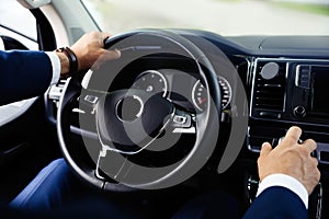 Man driving his car, closeup view of hands on steering wheel