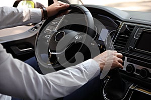 Man driving his car, closeup view of hands on wheel