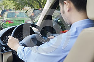 Man driving his car while texting with cellphone