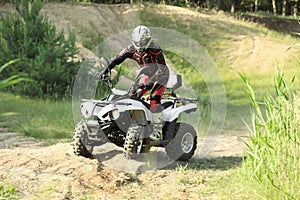 Man driving modern quad bike on sandy road. Extreme sport