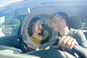 Man driving and next to woman are both wearing seat belts