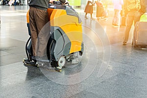 Man driving professional floor cleaning machine at airport or railway station. Floor care and cleaning service agency