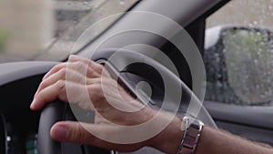 Man driving on rainy day, Derbyshire, UK