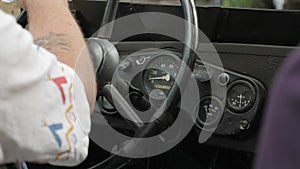 Man driving retro car, close up of steering wheel and control panel with speedometer. USSR old vintage car