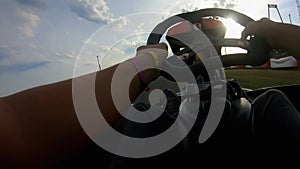 Man is driving a speedy go-cart on the race track outdoors